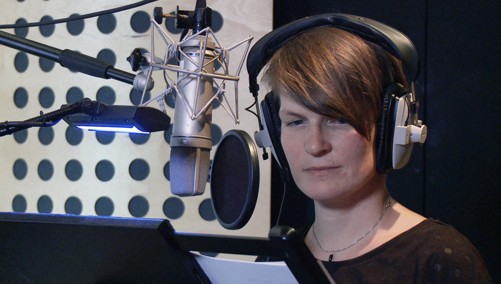 Image of filmmaker Birgit Gohlke in headphones in the documentary Screenability: Stuttering - My Constant Companion