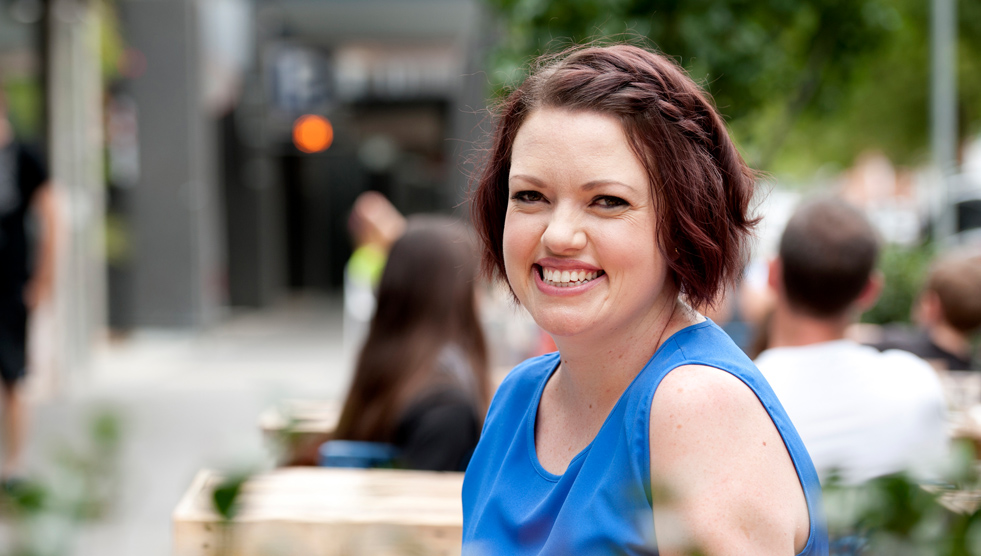 Ruth O'Brien by Grace Costa, 2016. Smiling woman sitting in an outside setting.